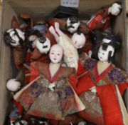 A collection of Japanese gofun dolls, some wearing kimonos, the largest 30cm high