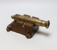 A miniature bronze table cannon on stepped base, 20cm wide