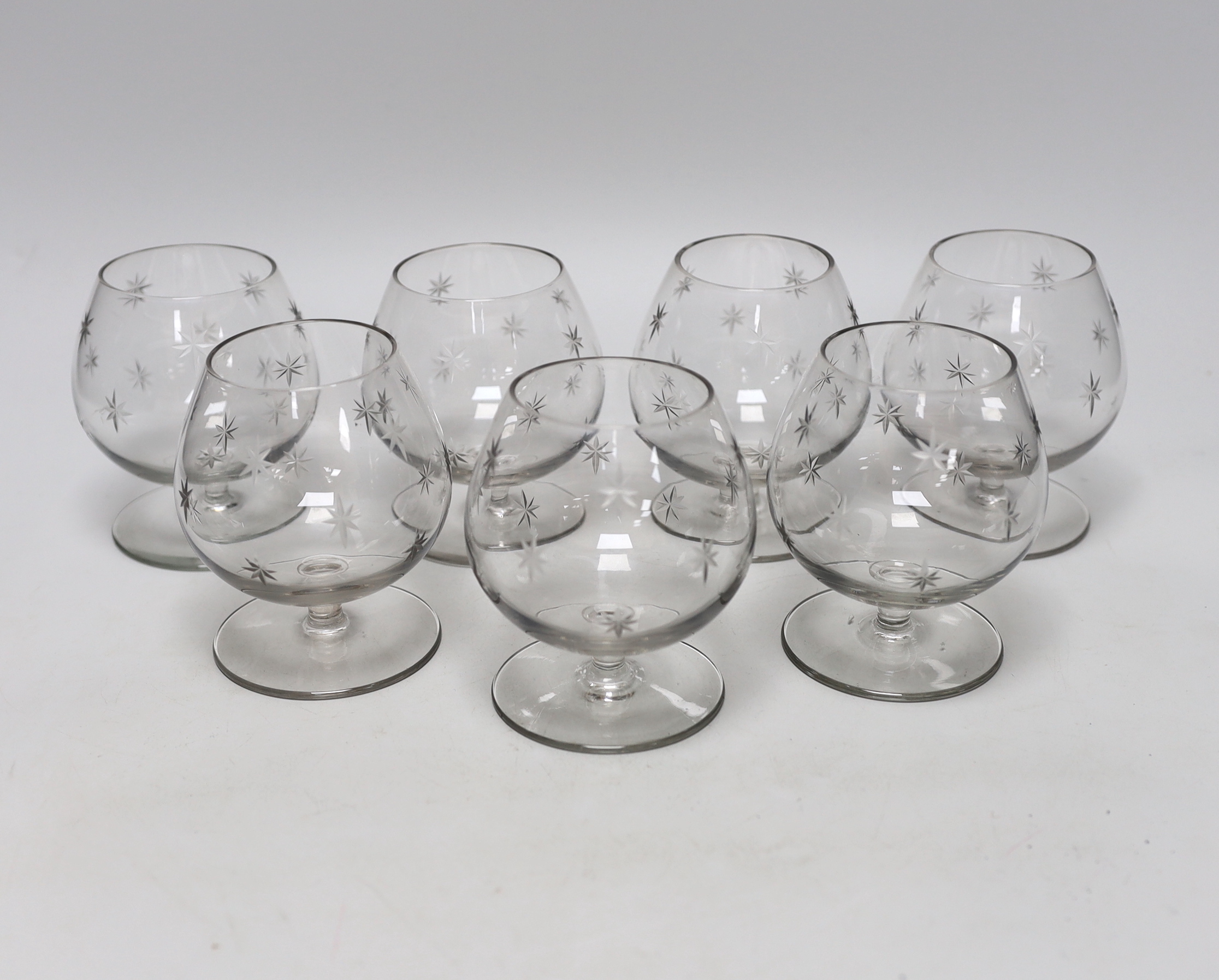 A set of seven cut glass brandy balloon glasses, with pattern of stars to each, 10.5cm high