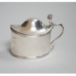 A George III oval silver drum mustard, with domed cover, glass liner and plated spoon, makers Peter,