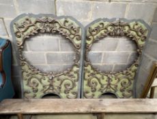 A pair of painted composition panels with oval scroll work apertures, width 96cm, height 146cm