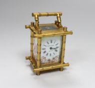 A French bamboo design carriage clock, with three porcelain putti decorated sides, by Elliot &