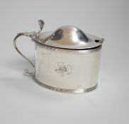A George III oval silver drum mustard, with domed lid, blue glass liner and associated plated spoon,