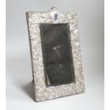 A late Victorian embossed silver rectangular toilet mirror, with scroll decoration, London 1899,