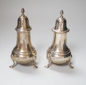 A near pair of George VI silver casters, with baluster bodies and pad feet, makers Elkington & Co,