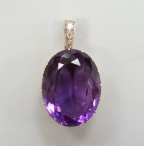 An Edwardian yellow metal, oval cut amethyst and three stone diamond set drop pendant, overall