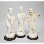 Seven Chinese blanc de Chine figures of immortals, each raised on carved hardwood bases, the largest