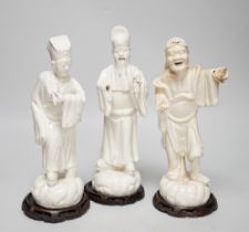 Seven Chinese blanc de Chine figures of immortals, each raised on carved hardwood bases, the largest