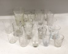 A collection of 19th and early 20th century drinking glasses, including beakers, some etched