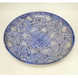 A large Moroccan pottery blue and white wall plate, 40cm diameter