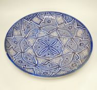 A large Moroccan pottery blue and white wall plate, 40cm diameter