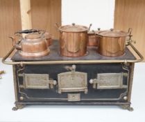 A Continental iron child's toy range/ stove, with a collection of copper fitted pans and a similar