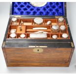 A Victorian combination walnut writing and toilet box, containing various silver lidded glass