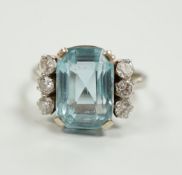 A white metal and single stone emerald cut aquamarine and six stone diamond set dress ring, size P/