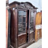 An early 20th century continental oak bookcase, lacking shelves and interior drawers, width 143cm,