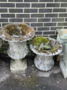 A pair of reconstituted stone circular campana garden urns, one lacks base, larger diameter 44cm,
