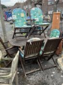 An octagonal stained teak folding garden table, length 150cm, depth 85cm, height 71cm and six