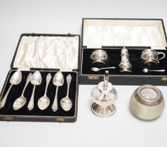 A cased George V silver three piece condiment set with two spoons, London, 1935, a cased set of