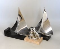 An Art Deco chrome model of a lioness drinking, possibly a car mascot and a pair of chrome yacht
