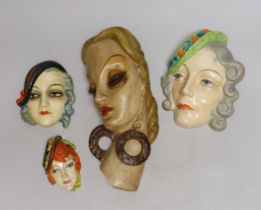 Four various pottery or plaster face masks, largest 28cm