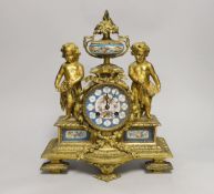 A French decorative ormolu putti mantel clock with porcelain clock face, side panels and urn