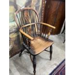 A 19th century Windsor ash and elm comb back elbow chair with crinoline stretcher, width 54cm, depth