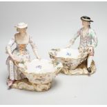 A large pair of Meissen salts in the form of a seated man and a woman in 18th century dress (a.