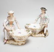 A large pair of Meissen salts in the form of a seated man and a woman in 18th century dress (a.
