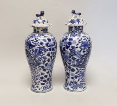 A pair of Chinese blue and white 'dragon’ vases and covers, Late 19th century, 29cm high