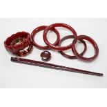 Eight simulated cherry amber items including four bangles and two bracelets.