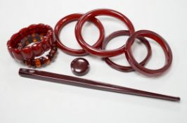 Eight simulated cherry amber items including four bangles and two bracelets.