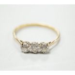 A yellow metal and three stone diamond set ring, size S/T, gross weight 2.1 grams.