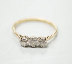 A yellow metal and three stone diamond set ring, size S/T, gross weight 2.1 grams.