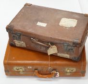 Two vintage suitcases with various labels including British Railways Waterloo, the largest 61cm