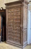 An early 20th century French oak notaries cabinet with 20 fall front compartments, width 125cm,