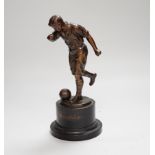 A pre-war bronze figure of a footballer, raised on a circular ebonies wood base, 23cm high
