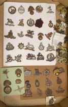 A collection of military cap badges, including Royal Sussex Reg, Royal Warwickshire, King’s Own