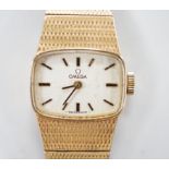 A lady's Omega 9ct gold manual wind wrist watch, with integral 9ct gold bracelet, gross weight 31.