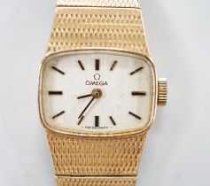 A lady's Omega 9ct gold manual wind wrist watch, with integral 9ct gold bracelet, gross weight 31.