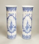 A pair of Delft blue and white cylindrical vases, each decorated with boats, 30cm high