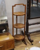 An Edwardian walnut three tier folding cake stand