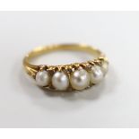 An Edwardian yellow metal and graduated split pearl set half hoop ring, with diamond chip spacers,