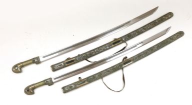 A pair of reproduction Turkish swords with white metal filigree scabbards, blades 80cm