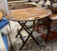 A Victorian brass mounted oval mahogany folding butler's tray / table on stand, width 90cm, height