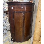 A 19th century George III bow-fronted hanging mahogany corner cupboard, width 84cm, depth 59cm,