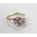 A 14k and three stone diamond set crossover ring, size H, gross weight 2 grams.