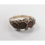 A 19th century yellow metal and graduated four stone foil backed garnet set half hoop ring, with