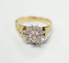 A modern 18ct gold and diamond chip set flower head cluster ring, size P, gross 4.5 grams.