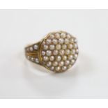 An Edwardian 15ct and seed pearl cluster set dress ring, with seed pearl set shoulders, size J/K,