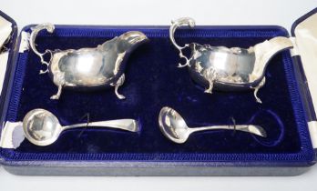 A cased pair of Edwardian silver sauceboats and pair of matching sauce ladles by Edward Barnard &